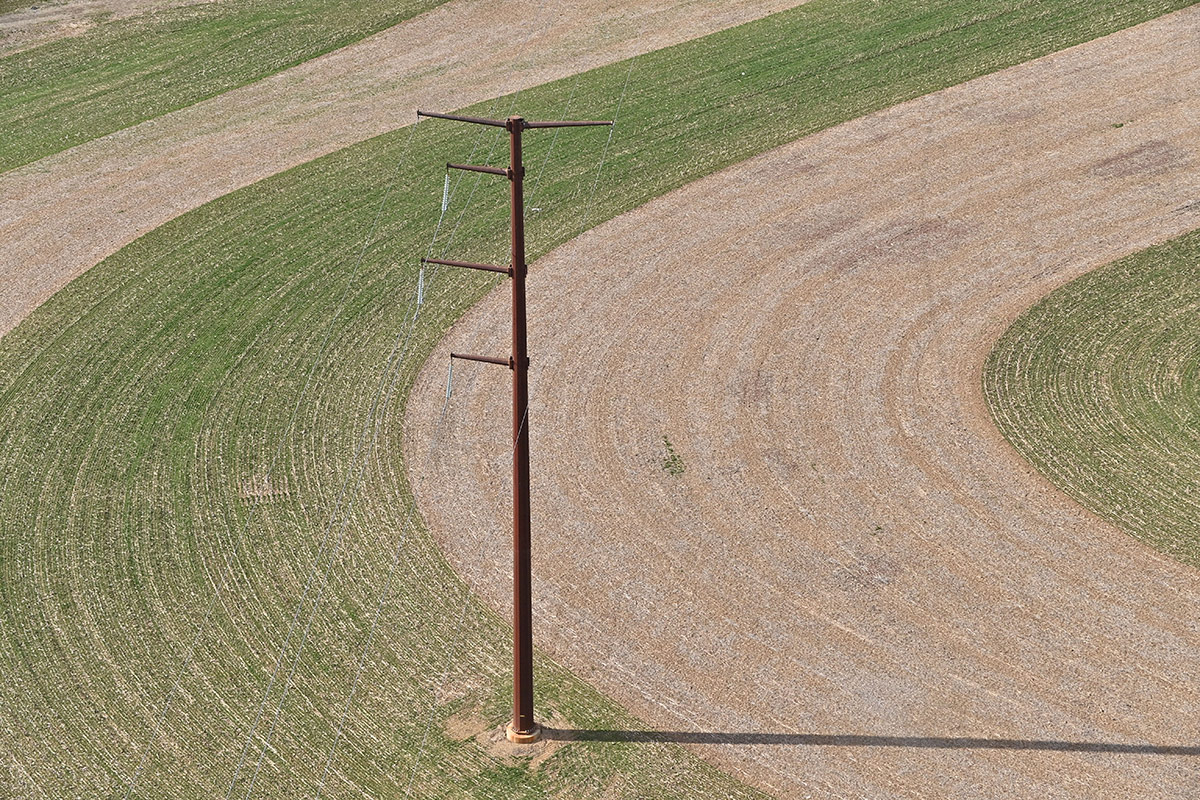 Transmission lines and a transmission tower in a field. 