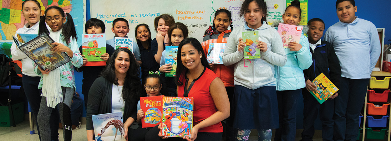 PPL employees and students holding books in classroom