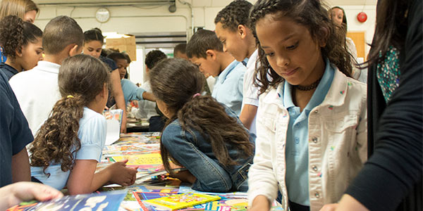 Child picking books from Cover to Cover