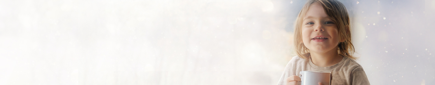 child smiling holding a mug