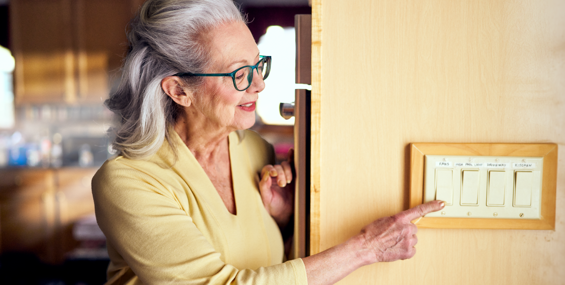 older woman turning off light switch