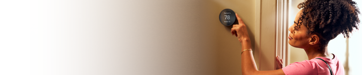 woman adjusting her thermostat