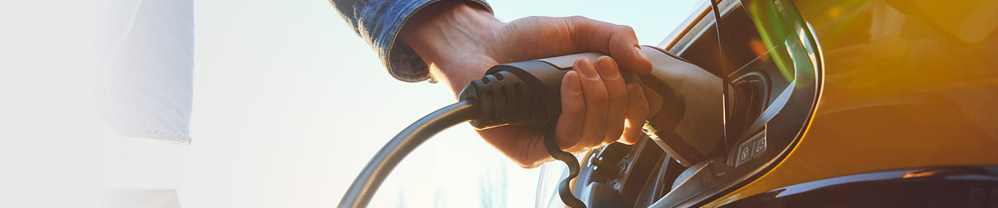 person plugging in their electric vehicle