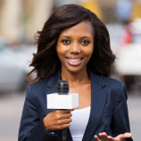 news woman holding microphone and smiling at the camera