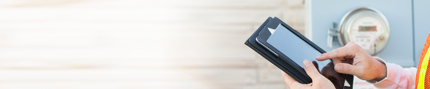close up of person standing next to meter entering information into tablet
