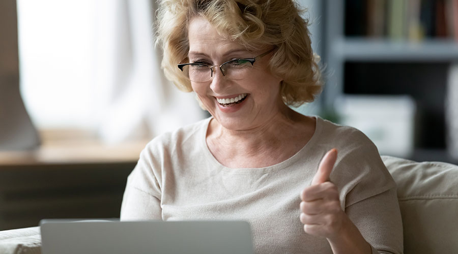 woman on laptop giving a thumbs up