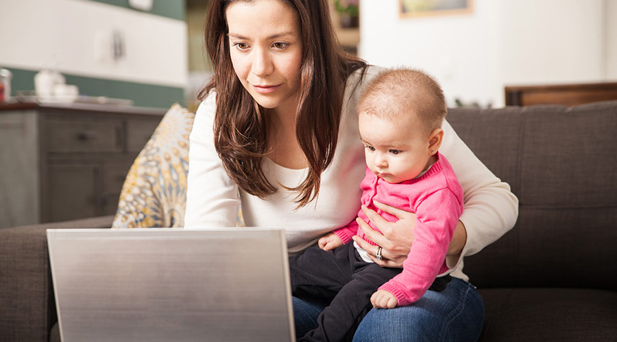 mom with baby on her lap reviewing her bills online