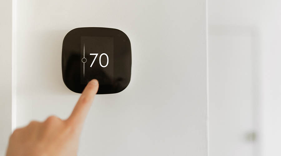 finger touching thermostat