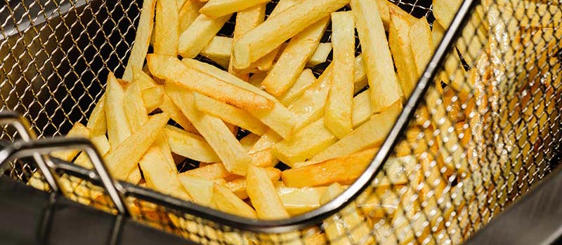 tight shot of french fries in an electric fryer