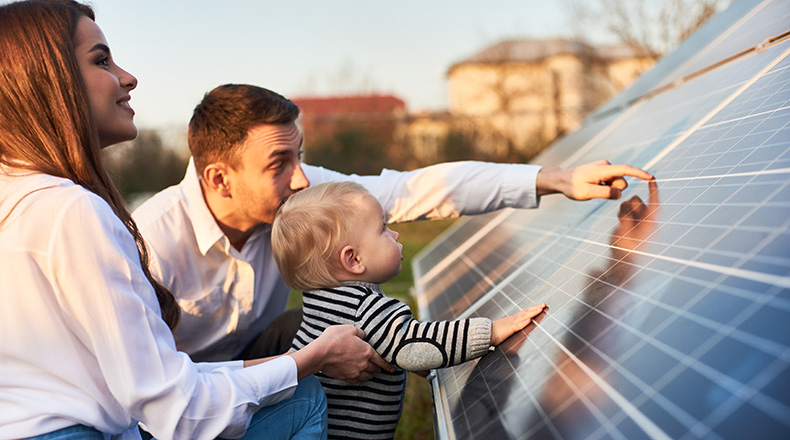 couple and child looking at a solar panel